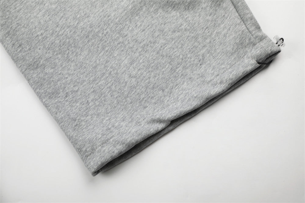 Close-up of gray sweatpants hem with subtle cuffed opening
