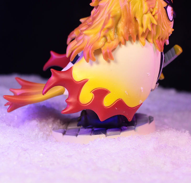 The Owl Cosplay Flame Hashira (Kyojuro Rengoku) Figure by Demon Slayer is a 11.5cm, 210g collectible showcasing vibrant yellow-red hair and a striking yellow cape. Seated on a snow-like base, he grips his sword with precision—a must-have for anime fans.