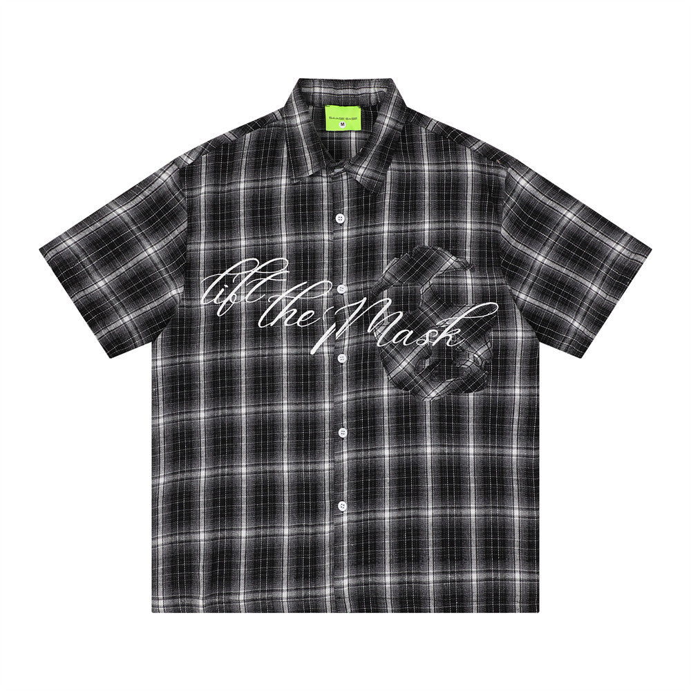 Oversized black plaid short sleeve shirt with white cursive embroidered script and 3D chest pocket graphic detail