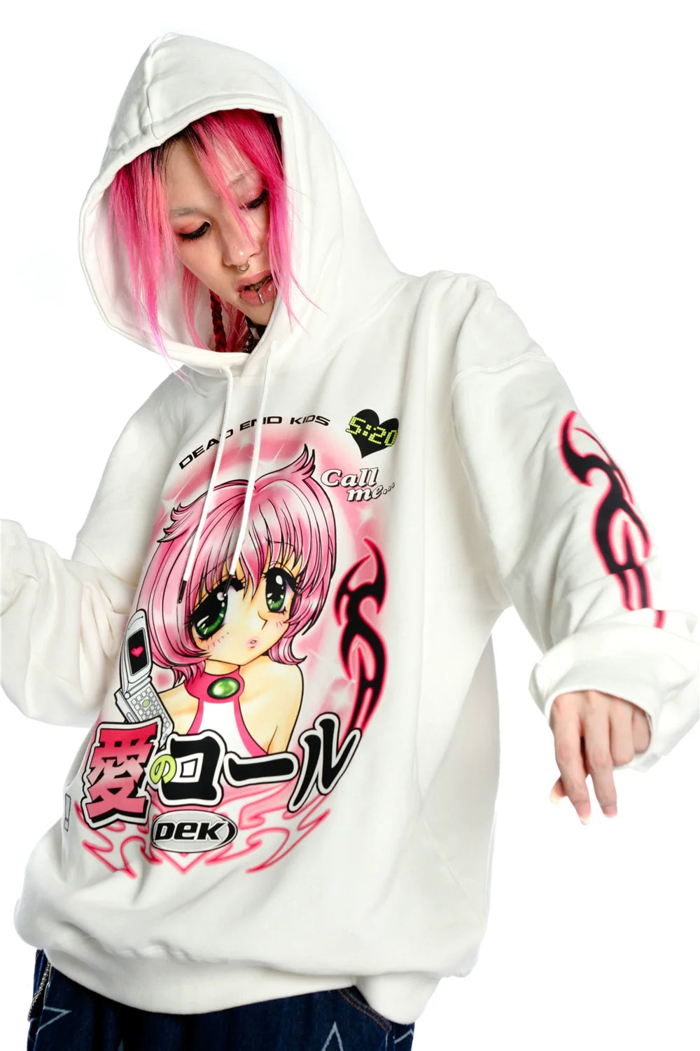A pink-haired person sports a Seakoff Y2K Aesthetic Anime Hoodie featuring a kawaii retro manga girl graphic and flaming sleeves, enriched with text and phone design elements on its white canvas.