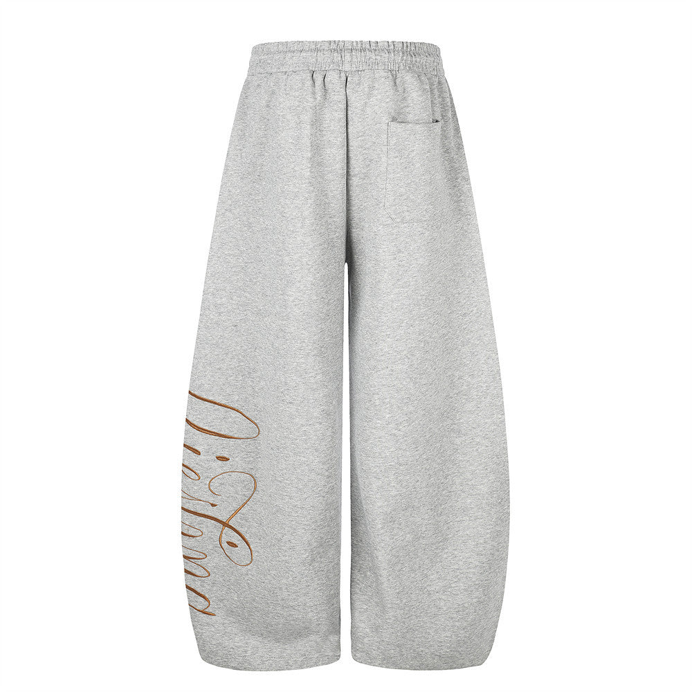 Back view of gray wide-leg sweatpants with rear pocket and script print on one leg
