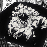 The Premium Yuta Okkotsu-Inspired Full Knit Sweater by Jujutsu Kaisen features a dynamic, multi-eyed monstrous creature with sharp teeth over a person, set against distorted black and white jacquard patterns, adding an edgy twist to streetwear fashion.