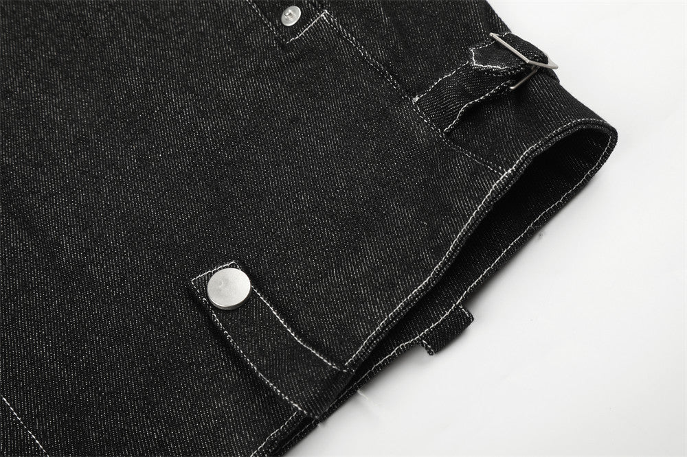 Close-up of black denim jacket side hem with snap tab and sleeve opening