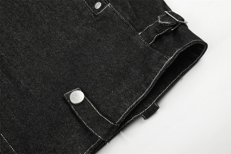 Close-up of black denim jacket side hem with snap tab and sleeve opening