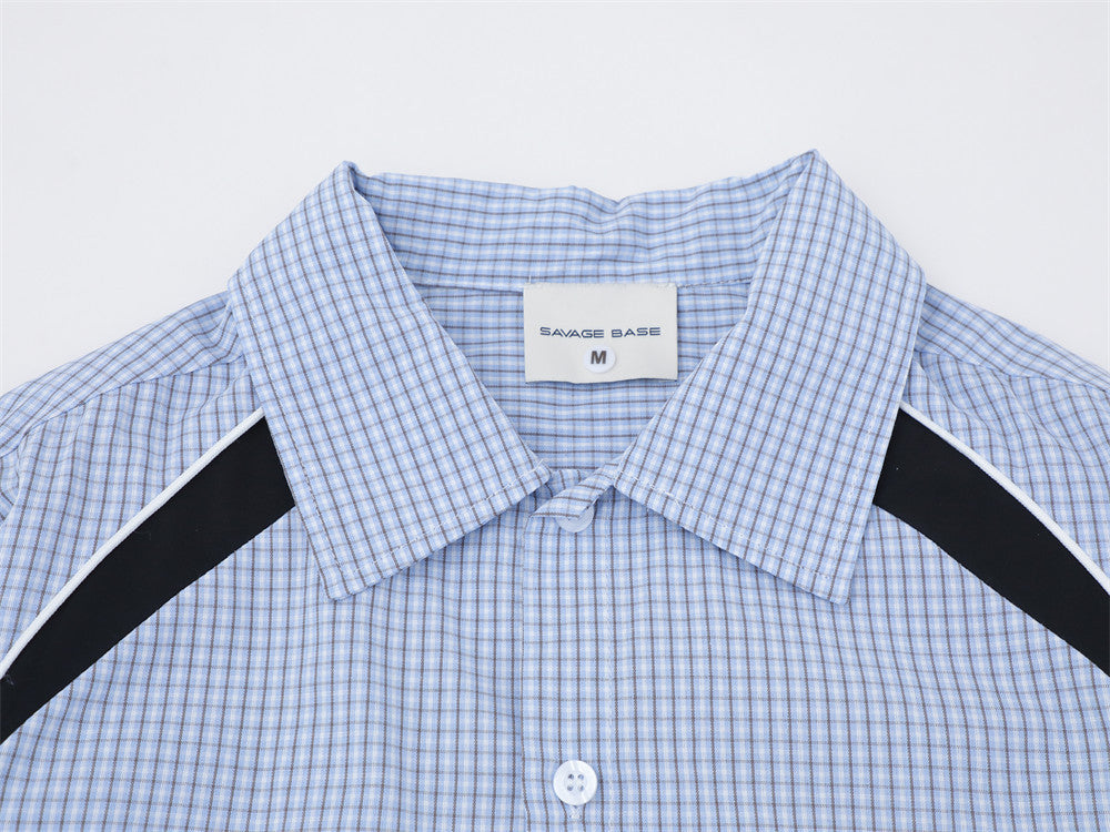 Close-up of the light blue plaid shirt collar, top buttons, and black shoulder panels