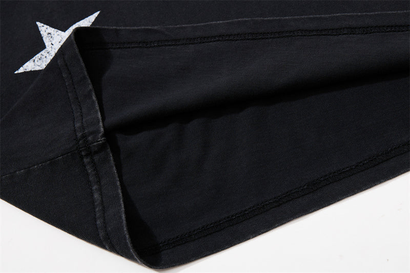 Close-up of side seam and stitched hem on black knit tee with star print