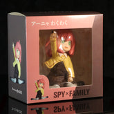 Explore the Anya Forger figure from "Spy × Family," featuring her in a yellow school uniform with interchangeable face. This vibrant collectible comes seated in a display box with Japanese text, making it an ideal addition for any anime fan&