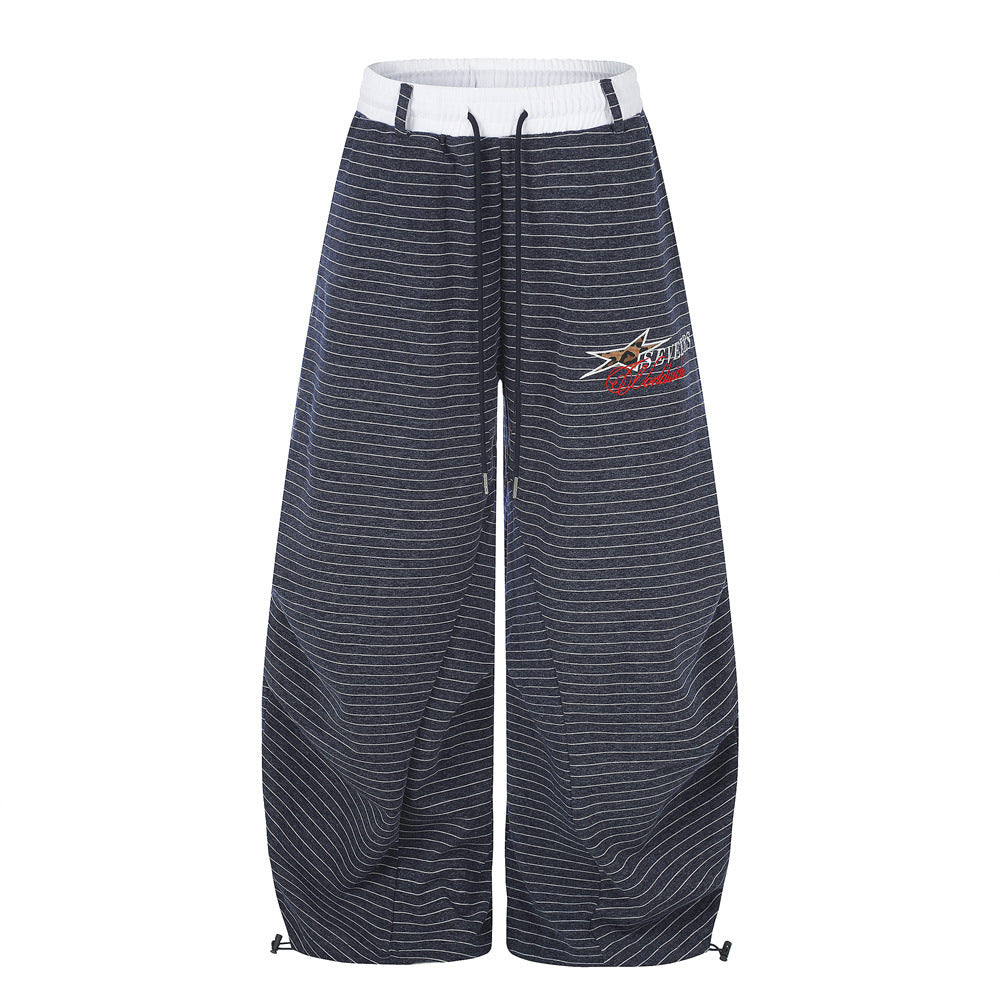 Oversized striped wide-leg sweatpants with contrast waistband and embroidered star logo, shown in navy and grey