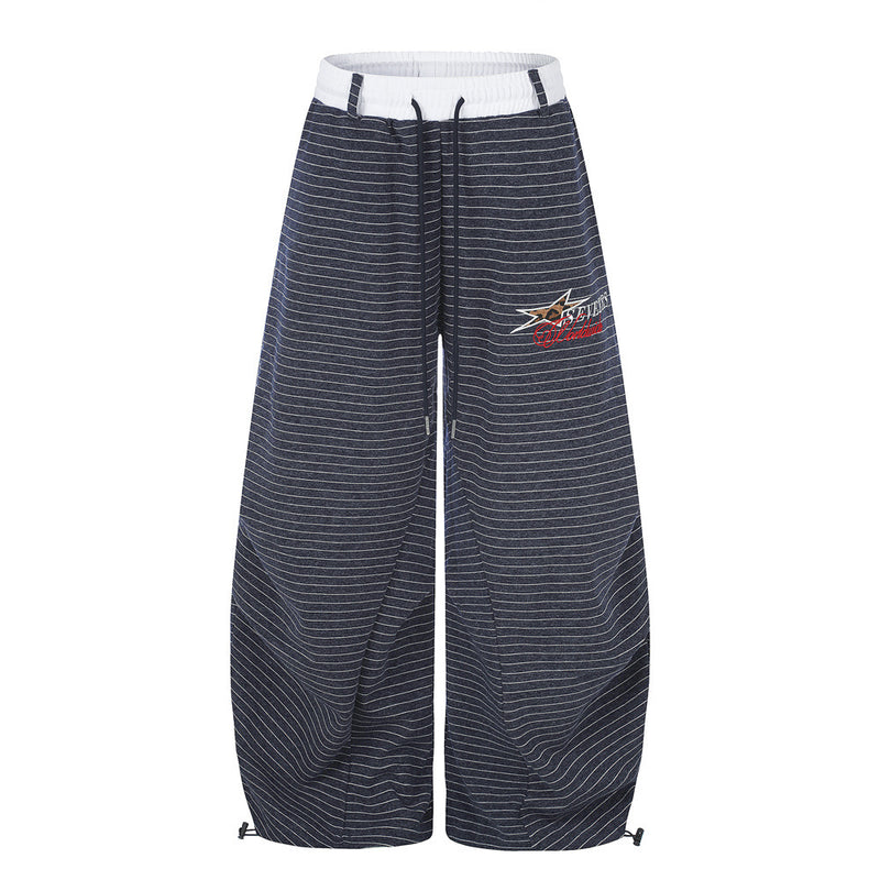 Oversized striped wide-leg sweatpants with contrast waistband and embroidered star logo, shown in navy and grey