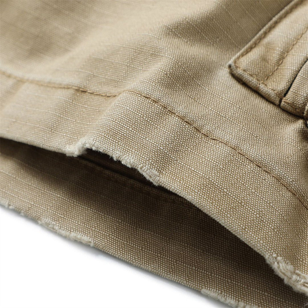 Close-up of khaki cargo shorts hem showing woven cotton texture and frayed edge