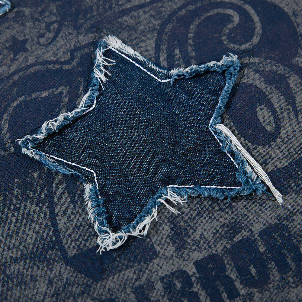 Close-up of a vintage star denim patch with frayed edges on a navy colorblock raglan T-shirt