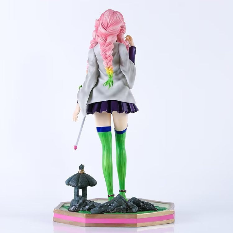 The 25cm Kanroji Mitsuri action figure from Demon Slayer features long pink hair, a short skirt, jacket, and long green socks with blue bands. It stands on a platform with a lantern-like decorative structure, making it a true Demon Slayer collectible.