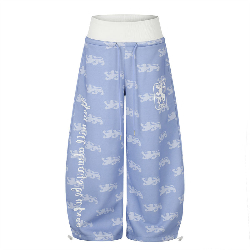 Pantalon de survêtement à jambes larges, imprimé intégral répétitif de lions héraldiques, ceinture côtelée contrastante taille haute et écusson brodé