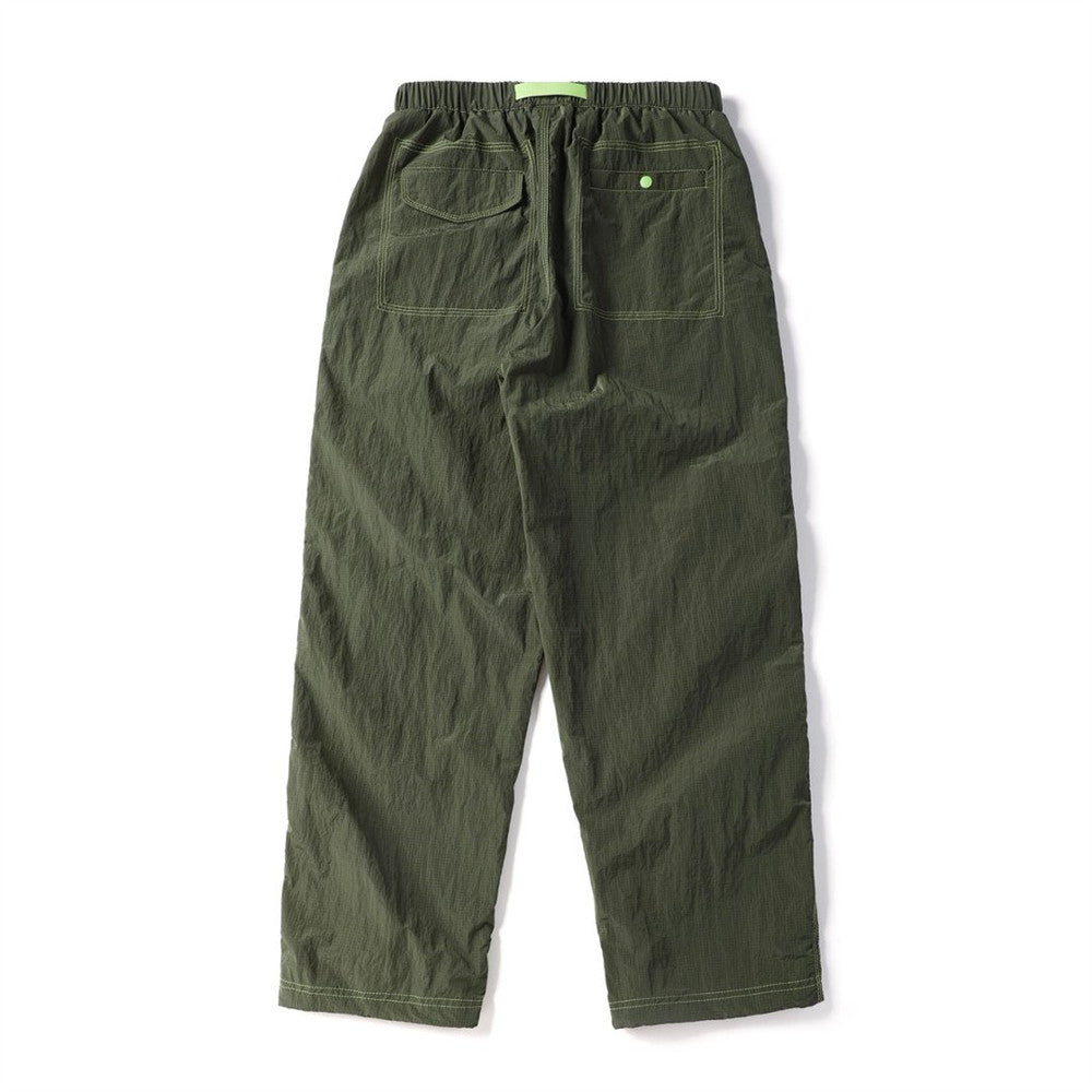 Back view of olive green parachute pants with two rear pockets and contrasting green stitching