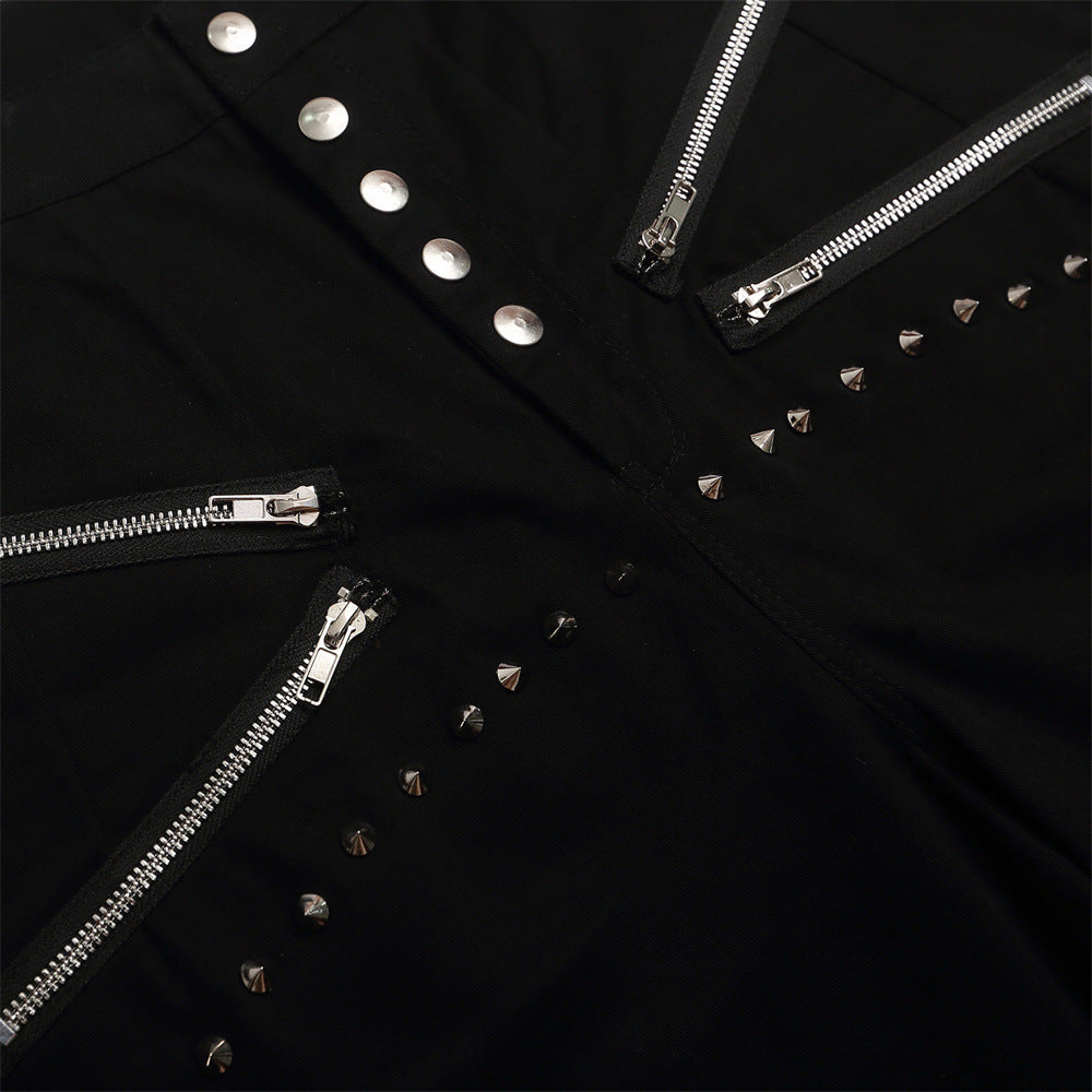 Close-up of black shorts front with diagonal zippers and silver studs
