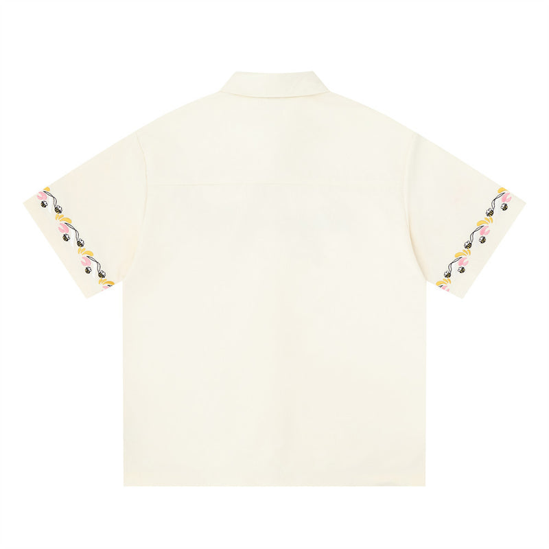 Cream short sleeve button-up shirt back view with floral embroidery on both sleeve hems
