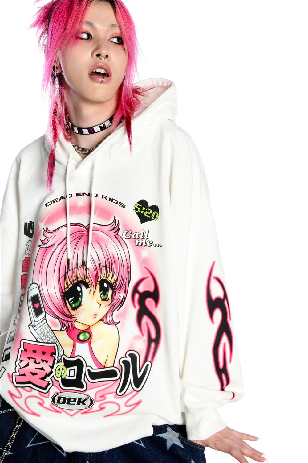 A person with pink hair wears Seakoff's Y2K Aesthetic Anime Hoodie, marked by a kawaii retro manga girl graphic and a phone design. Complemented by a spiked choker and tattoos, the hoodie features black, pink, and yellow text and designs, completing the Y2K aesthetic.