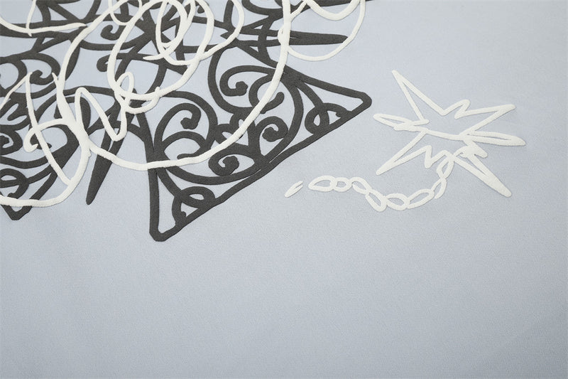 Close-up of star detail and graphic print on light blue long sleeve tee