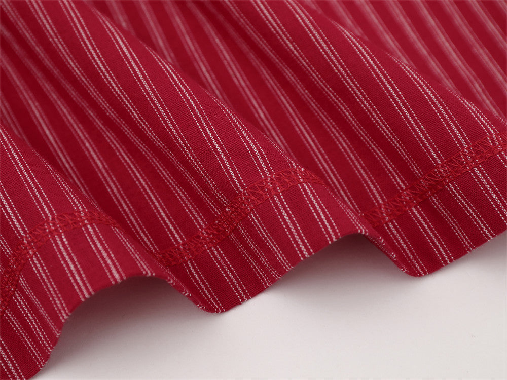 Close-up of red striped shirt hem with stitched edge and curved finish