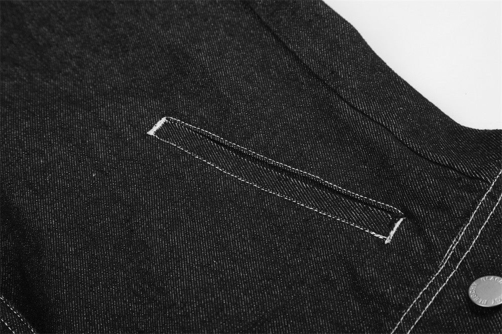 Close-up of black denim jacket back yoke and side pocket opening