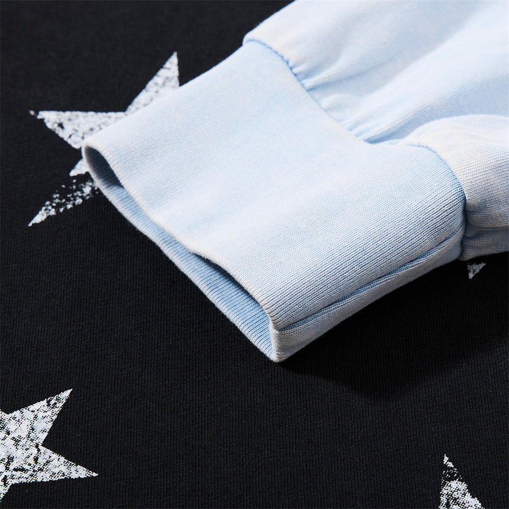 Close-up of light blue sleeve cuff and star print on black knit fabric