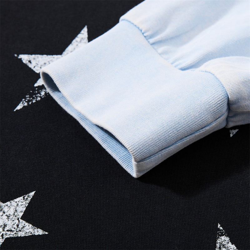 Close-up of light blue sleeve cuff and star print on black knit fabric