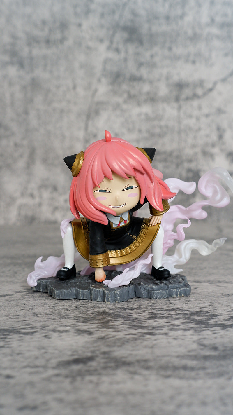 The Spy x Family Anya Forger 9.5 cm PVC figure features chibi-style pink hair with Luffy cosplay and cat ears, a dark outfit with a golden emblem, crouched on a swirling cloud-like base against a gray textured backdrop.