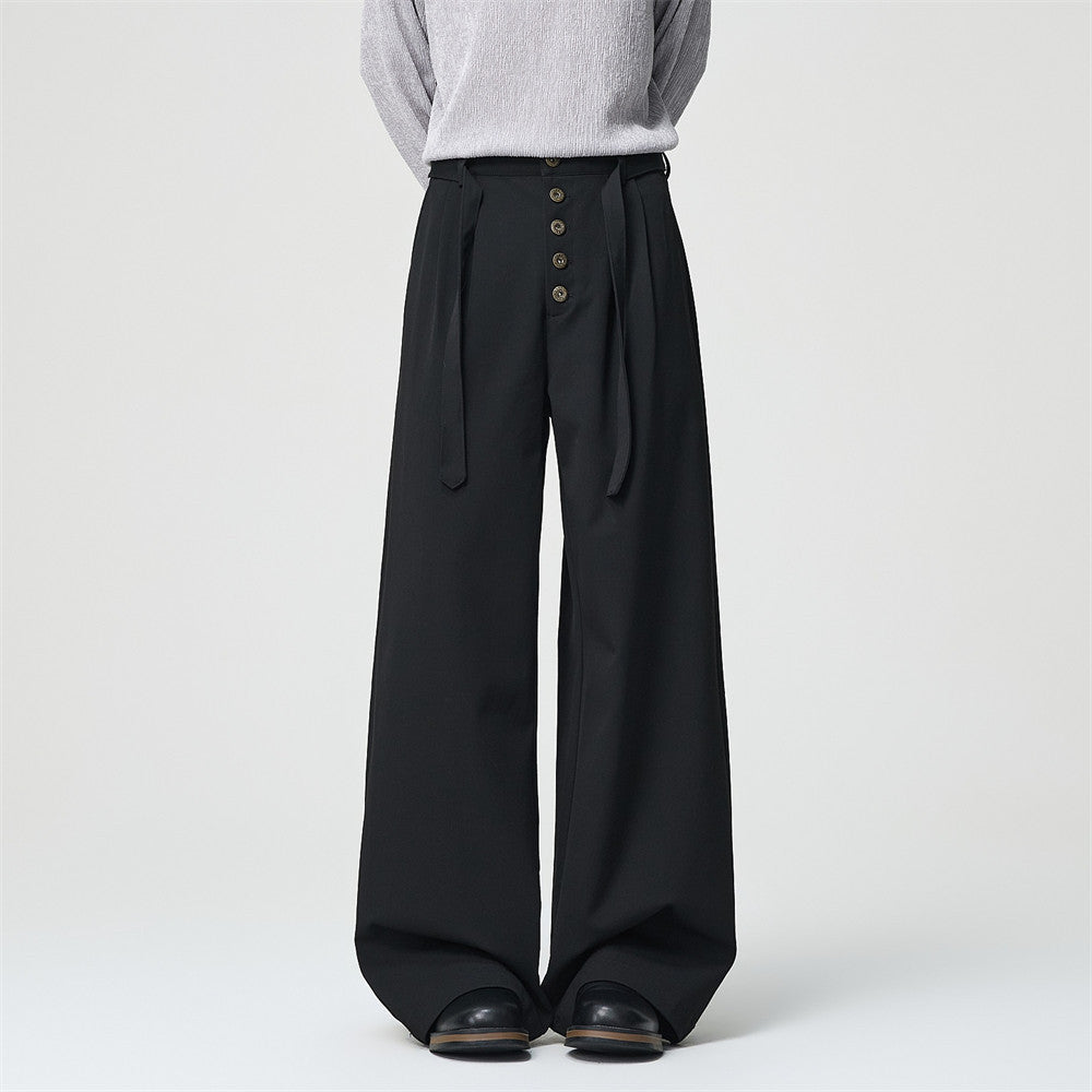 Men's black wide-leg pleated dress pants with button-fly placket and self-tie belt, front and back view