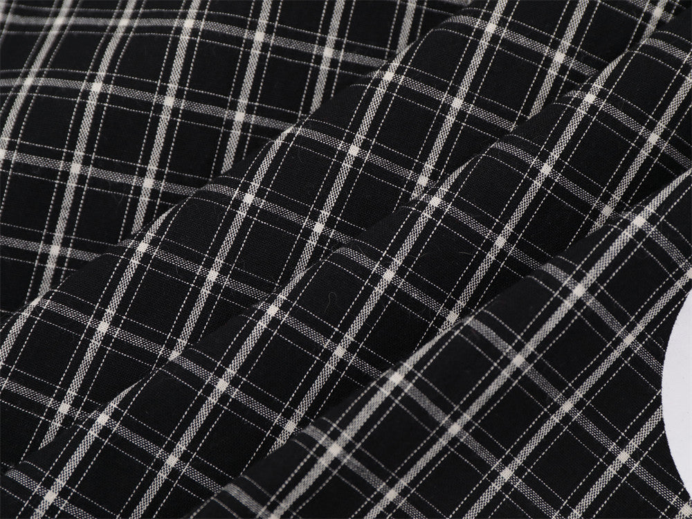 Close-up of black plaid fabric with folded sleeve and sleeve seam