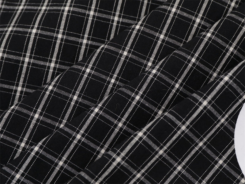 Close-up of black plaid fabric with folded sleeve and sleeve seam