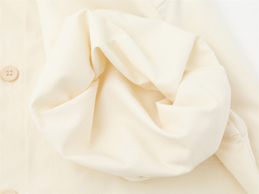 Cream shirt sleeve close-up showing gathered fabric and seam detail