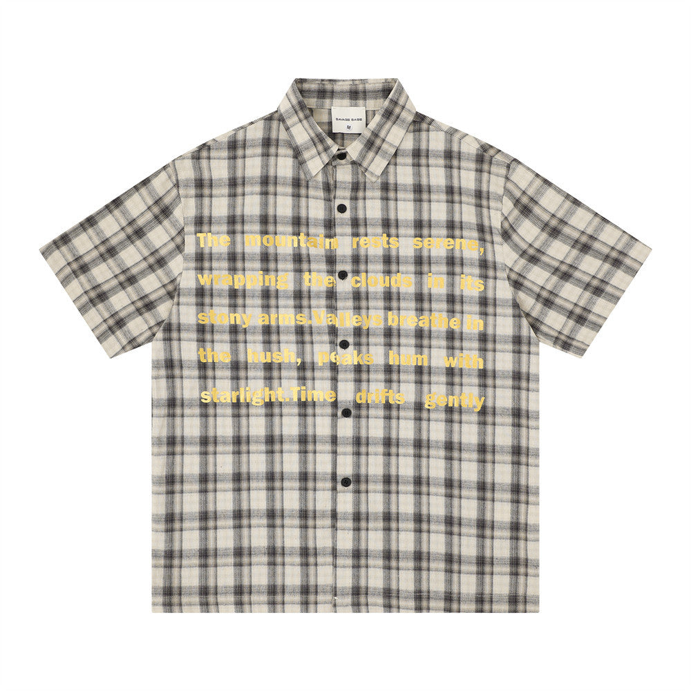 Oversized plaid short-sleeve shirt with yellow letter print on chest in charcoal colorway, flat lay product photo