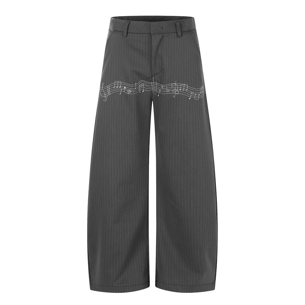 Grey pinstripe wide-leg trousers with white music note embroidery across the front thigh, front view