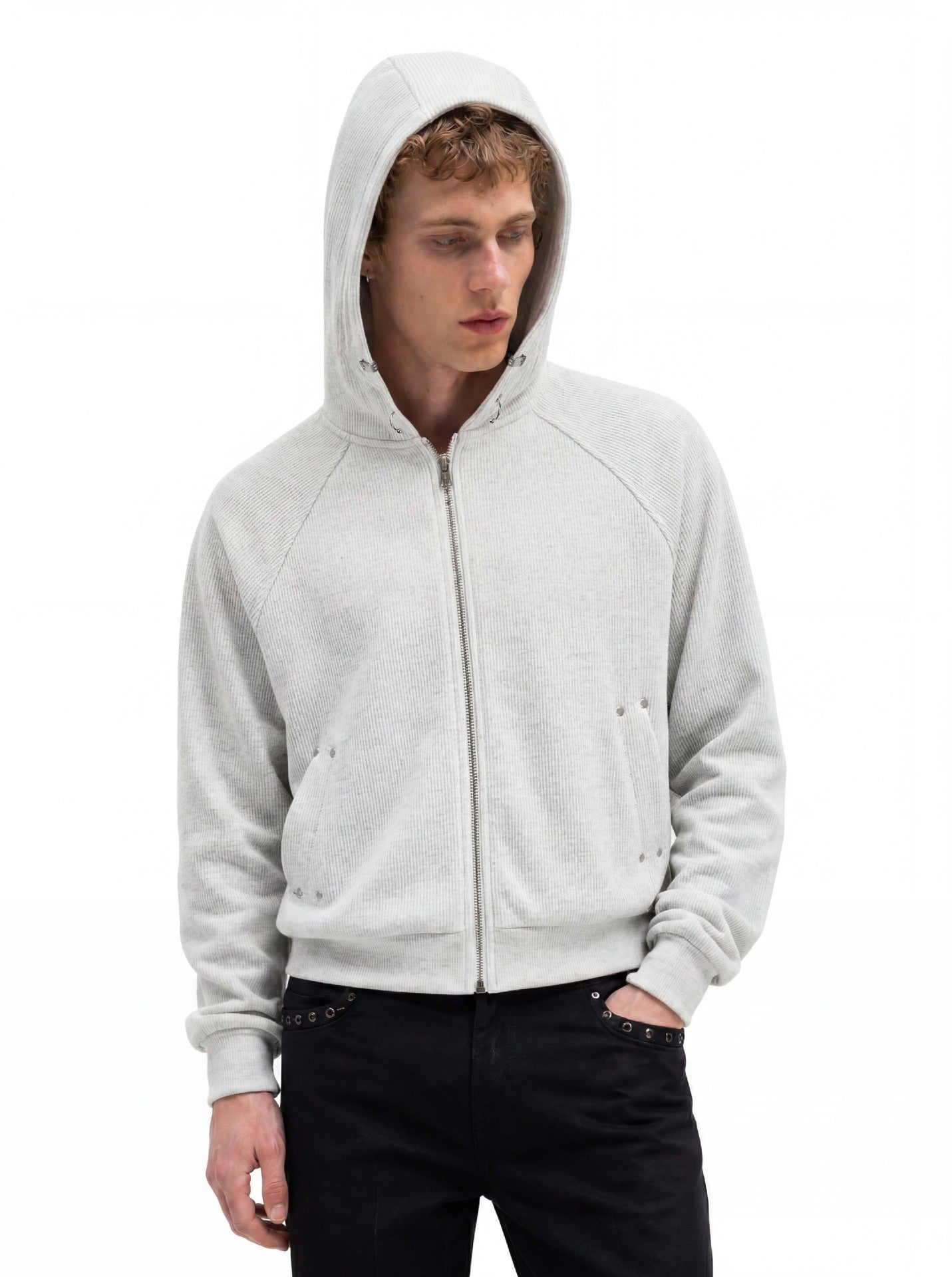 Sweat à capuche court zippé en maille côtelée, manches raglan et finitions métalliques argentées, gris chiné, porté avec un jean noir par un mannequin homme