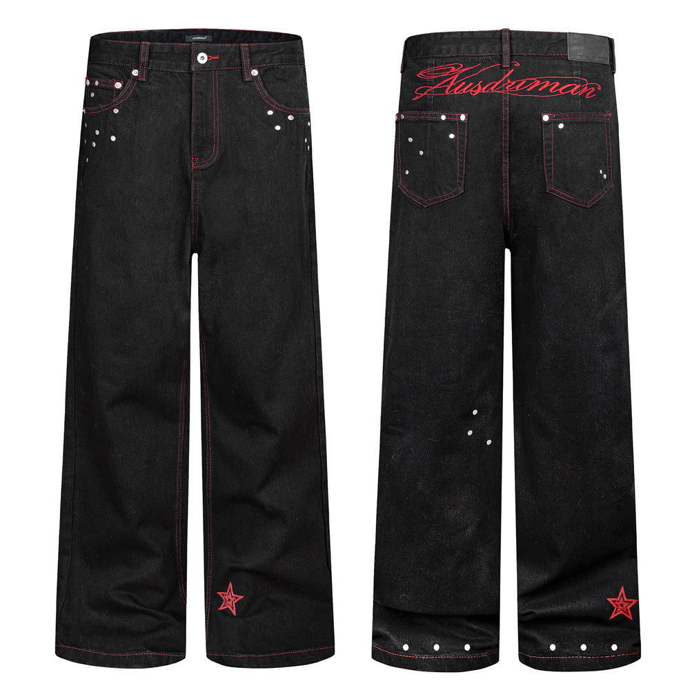 Jean homme noir à jambes larges, surpiqûres contrastantes rouges, ornements à clous argentés et broderie étoile rouge à l’ourlet, vues de face et de dos