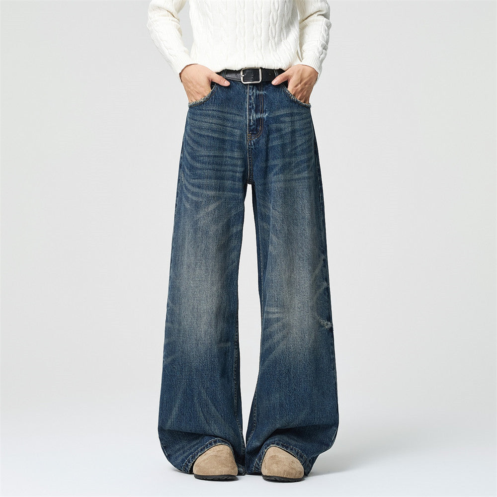Men's wide-leg distressed baggy jeans in vintage blue wash, front and back view showing hand-abraded whisker fading and relax