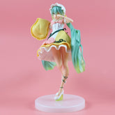 The Hatsune Miku Sleeping Beauty PVC Figure 20cm showcases her famous long green hair, a white apron over a yellow dress, a playful raised-foot pose, and white shoes while holding a yellow hat. It features a white base against an enchanting pink backdrop. Adorable collectible with box.