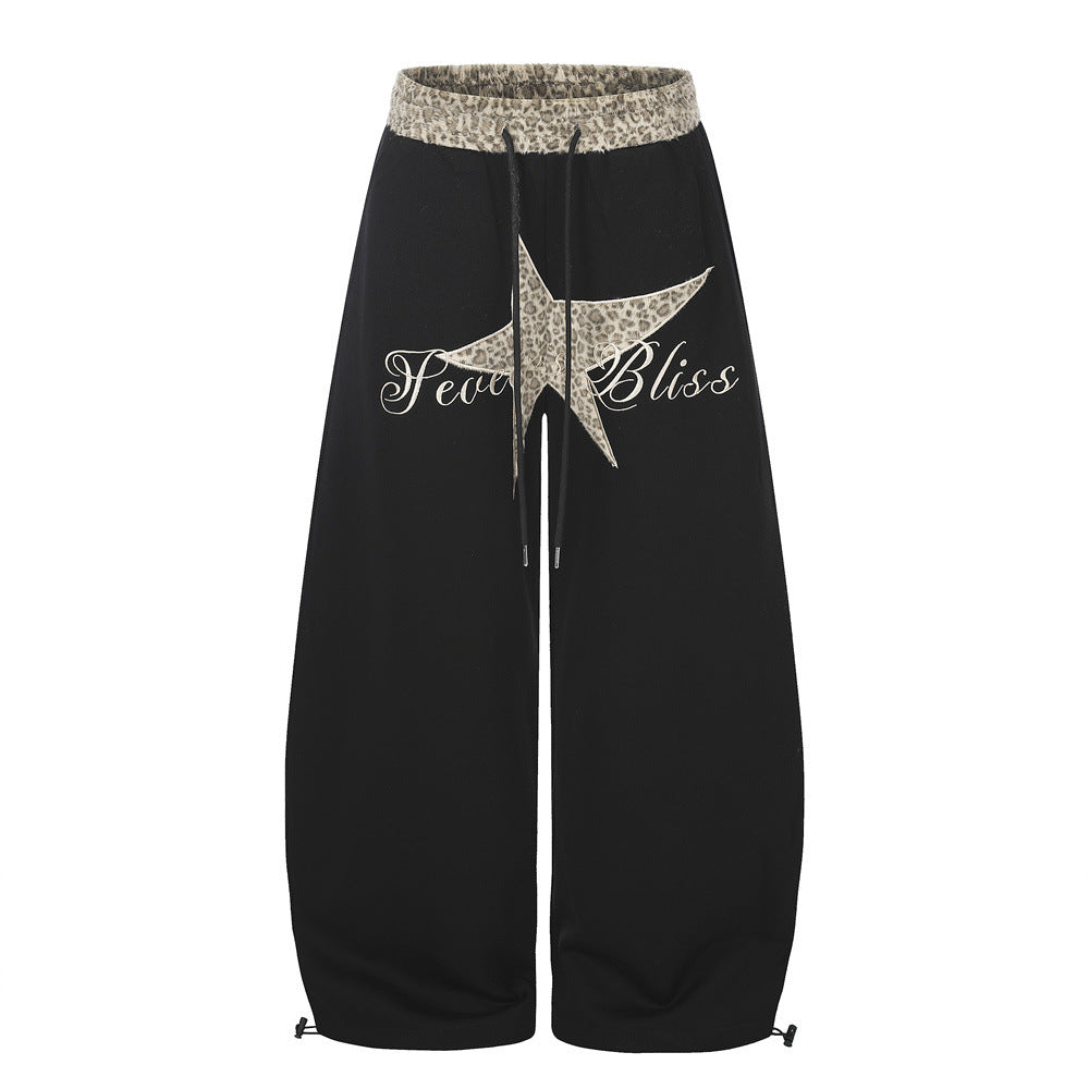 Men's wide-leg sweatpants in black with leopard-print star patch appliqué, matching waistband, and drawstring hem