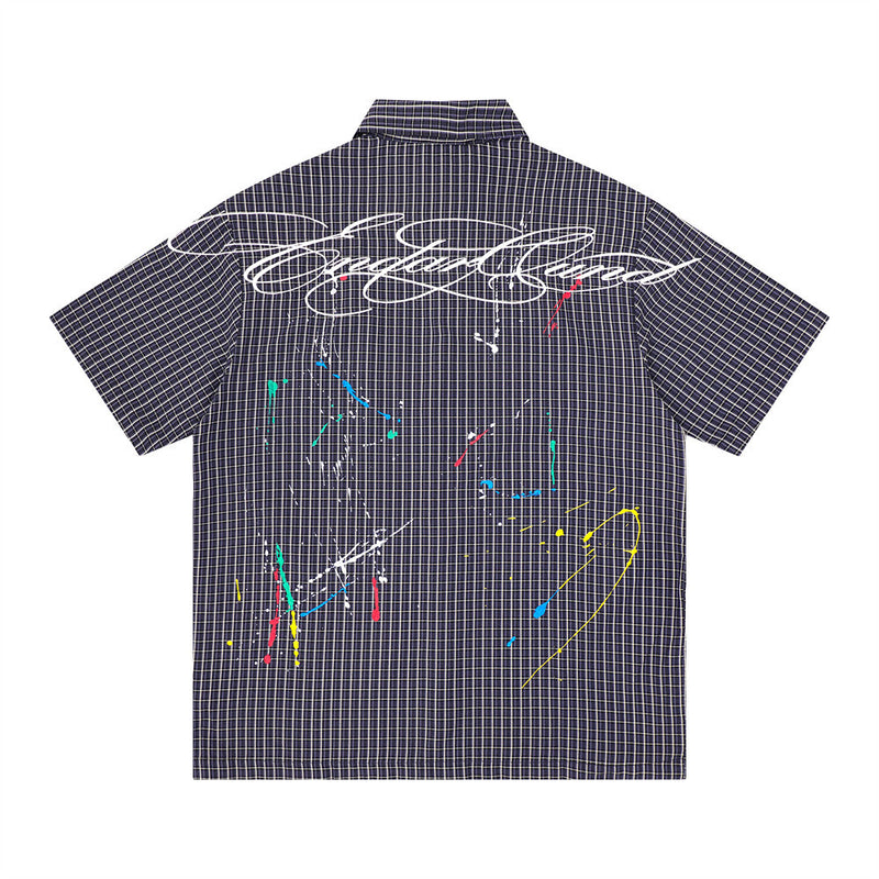 Back view of navy plaid short sleeve shirt with large white script print and multicolor paint splatter