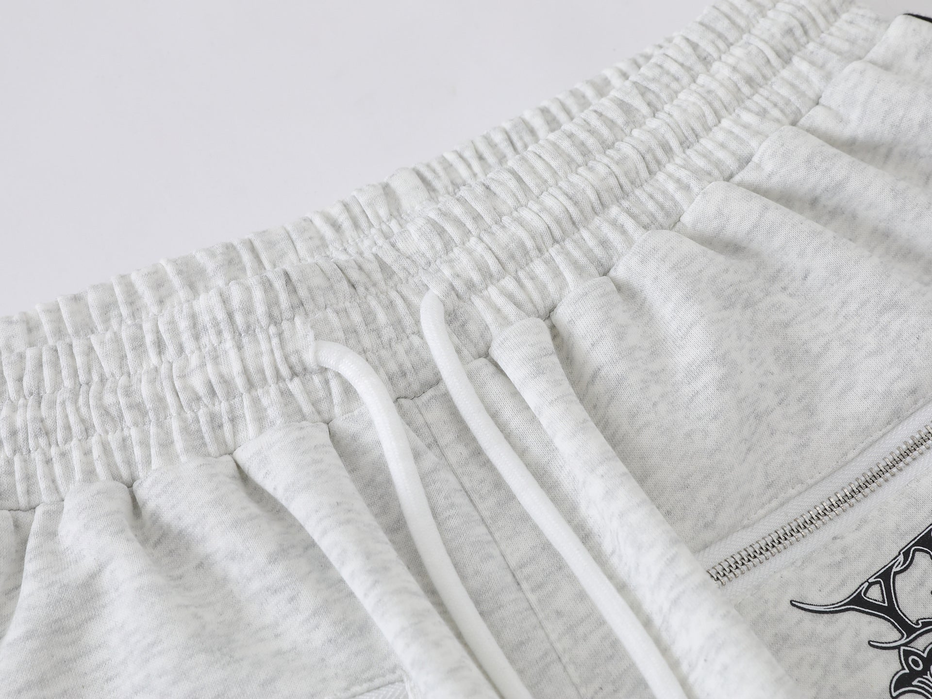 Pantalon de survêtement à jambes larges avec graphisme héraldique et détails latéraux multibandes