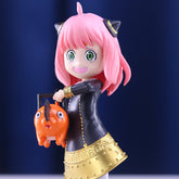 The Seakoff Anya Forger Chainsaw Cosplay Figure from *Spy x Family* showcases her playful charm with pink hair and cat ears in a black dress with gold accents, holding an orange creature against a blue background.