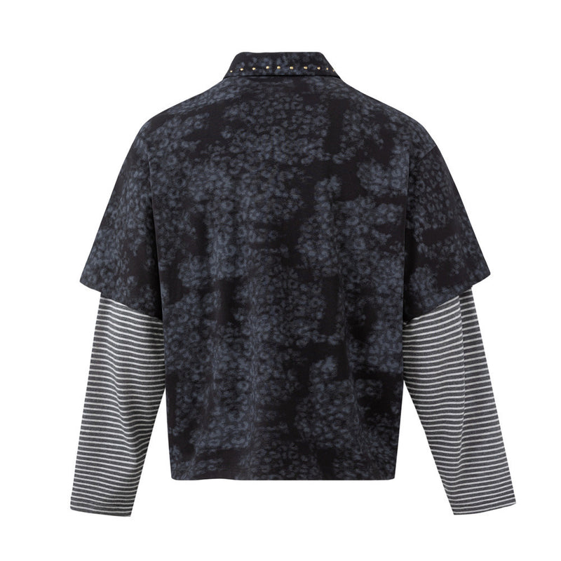 Back view of a dark mottled faux-layered polo shirt with contrasting striped sleeves and studded collar