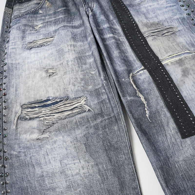 Jean large homme déchiré avec empiècement camouflage, clous et ceinture