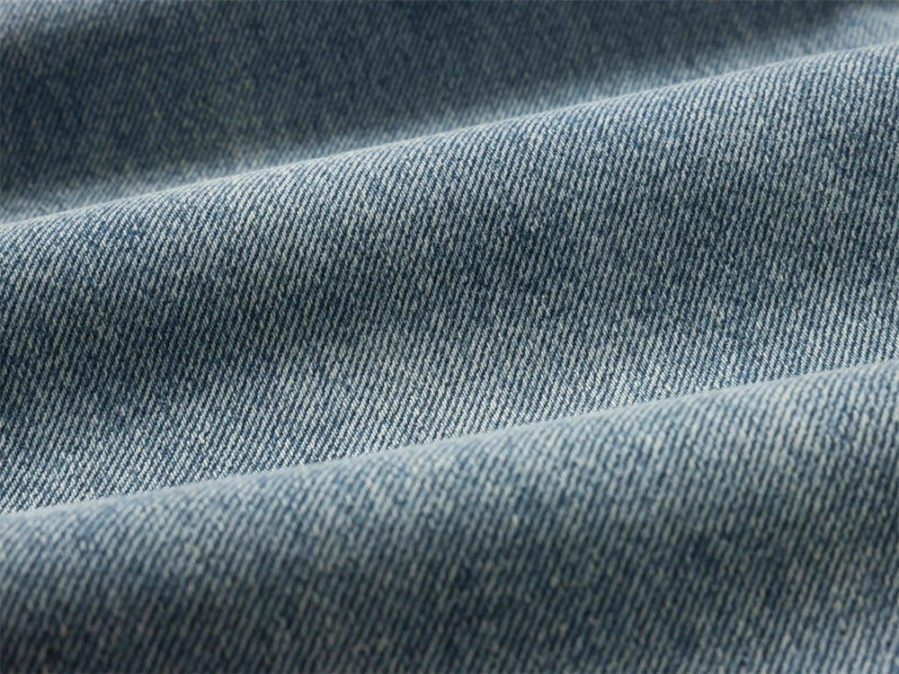 Close-up of light blue denim fabric with visible twill texture