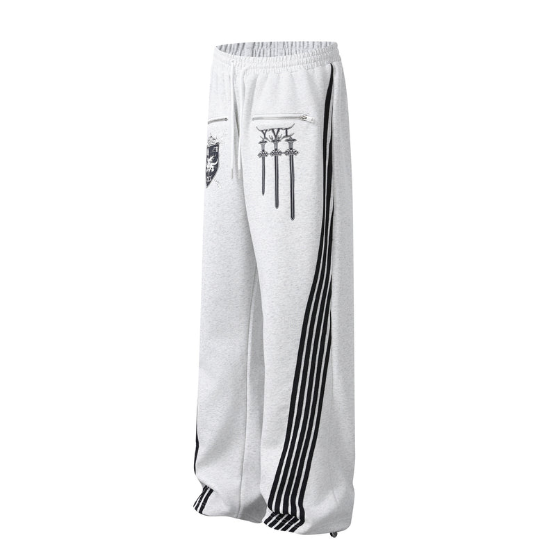 Pantalon de survêtement à jambes larges avec graphisme héraldique et détails latéraux multibandes