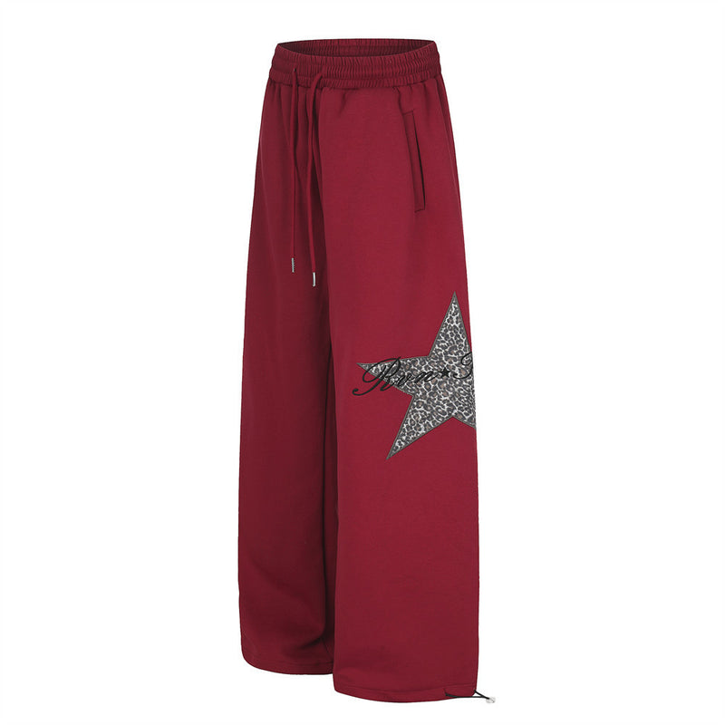 Red wide-leg sweatpants with leopard star patch, front view with drawstring waist
