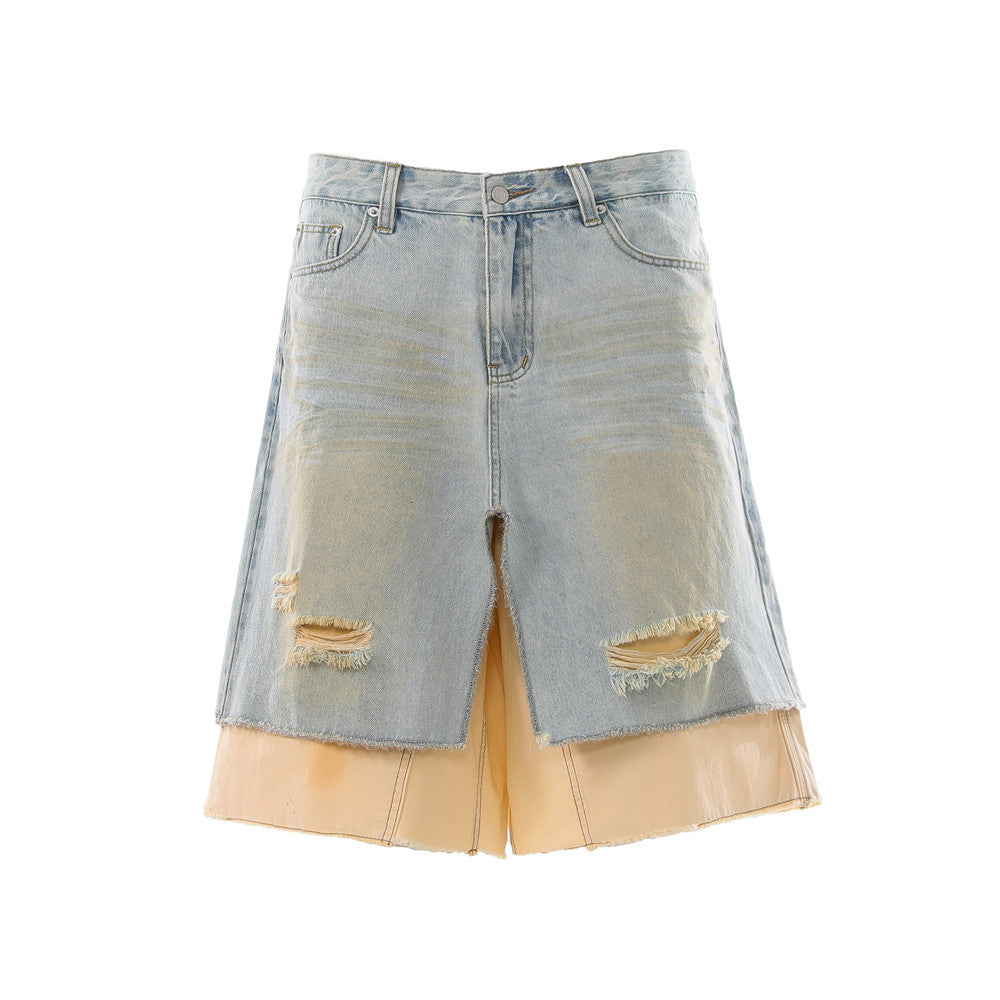 Men's light blue distressed denim skirt shorts with layered cream underlayer, frayed raw hem, and wide-leg silhouette, front
