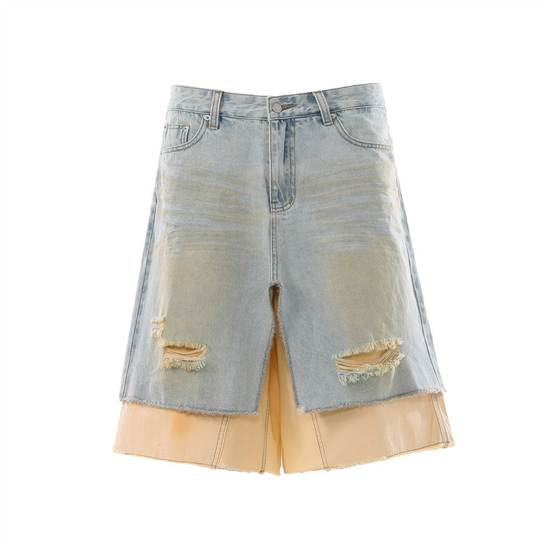 Men's light blue distressed denim skirt shorts with layered cream underlayer, frayed raw hem, and wide-leg silhouette, front