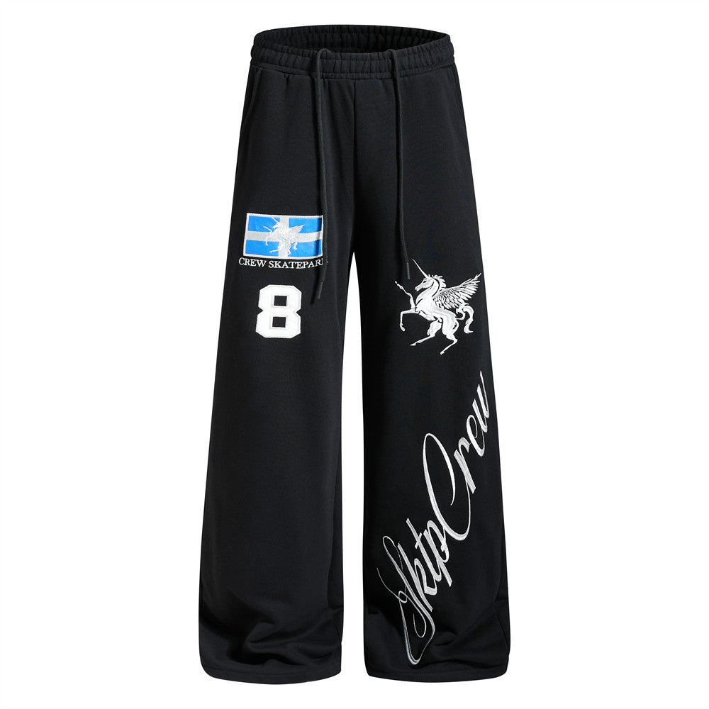 Black wide-leg sweatpants with embroidered Pegasus, Crew Skatepark flag patch, number 8 appliqué, and Sktp Crew script graphi