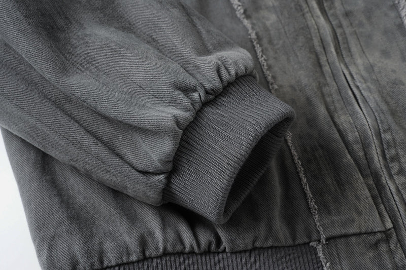 Veste bomber en jean délavé déconstruite à empiècement croisé et coutures effilochées
